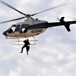 Game Warden rappelling from a helicopter